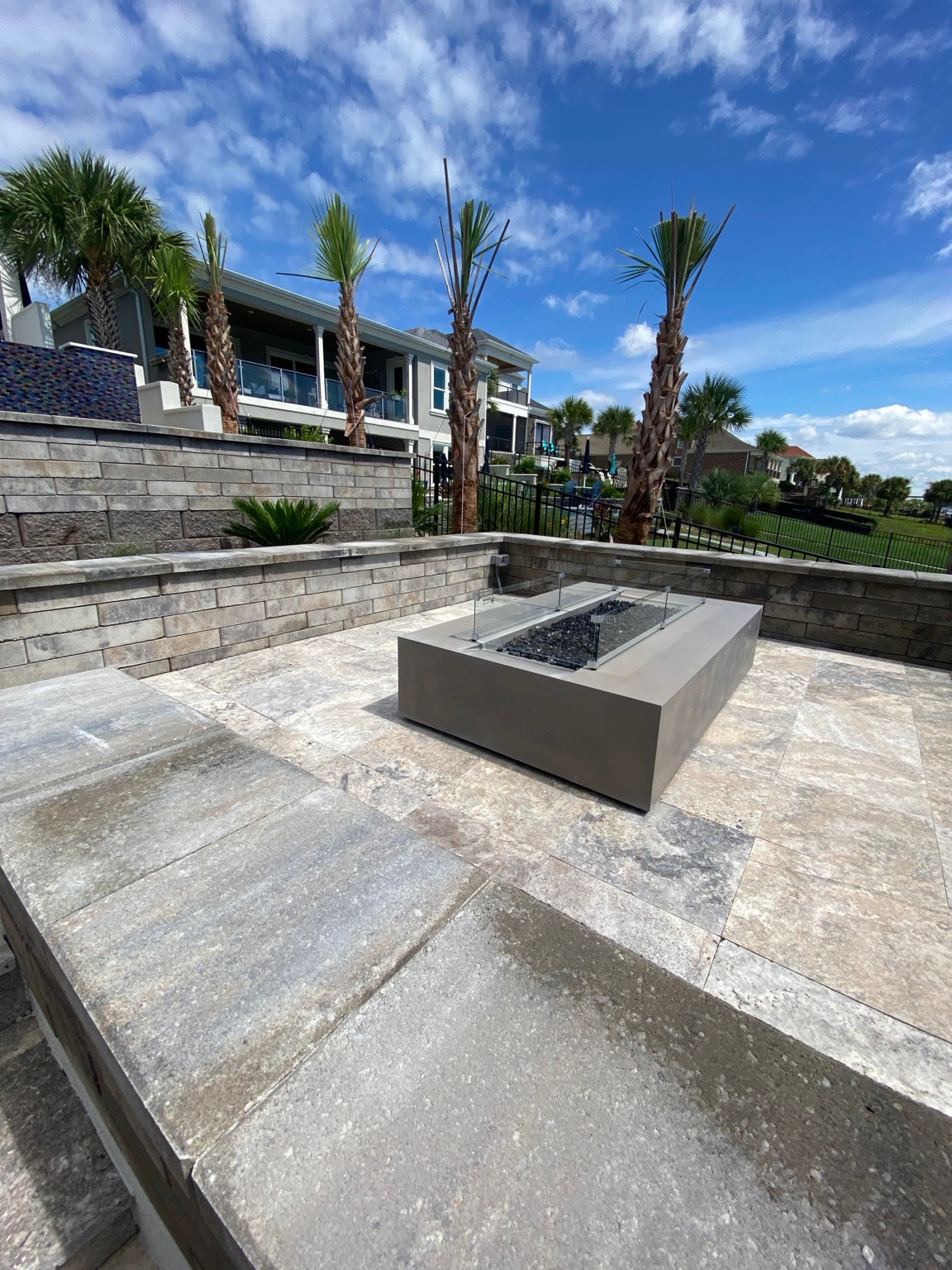 Stone patio with a fire table and seat walls