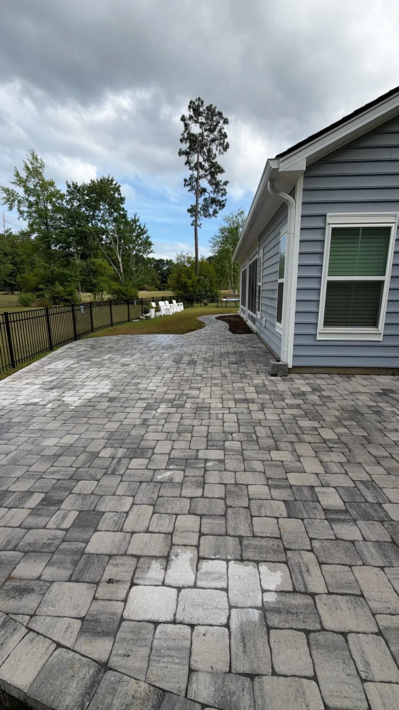 Paver patio connecting to a walkway beside a home